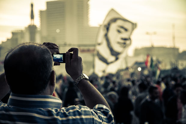 An Egyptian man takes a photo of a large anti-Morsi protest in Tahrir Square, Egypt (Photo: Phil Gribbon/Alamy)