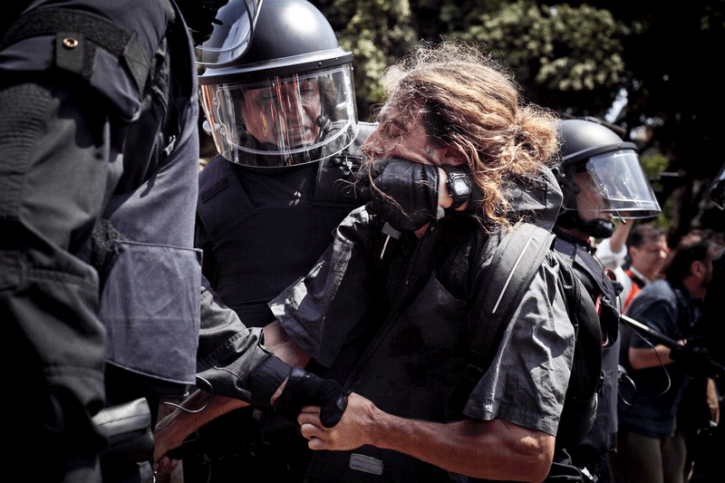 An "indignado" struggles to escape from a policemen during riots in Barcelona's main square (Plaça Catalunya) during 'Movimiento 15M' --- The occupy movement in Spain. Juanfra Alvarez / Demotix Alvarez / Demotix