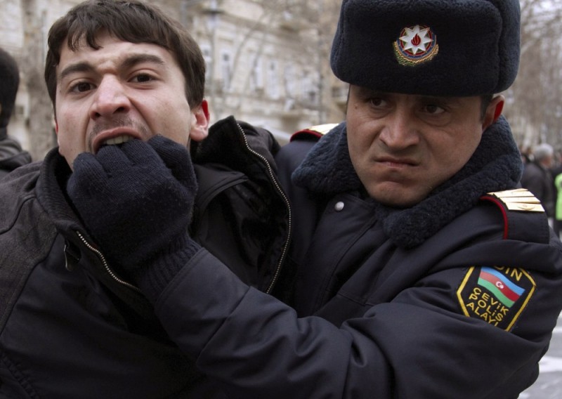 A policeman detains an opposition activist in Baku March 12, 2011 - REUTERS/Orhan Orhanov