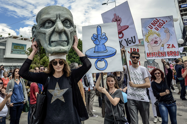 Crowds hold up signs as they demonstrate in front of the Bosnian parliament building in Sarajevo demanding laws for personal identification numbers for newborns. (Photo: Sulejman Omerbasic / Demotix)