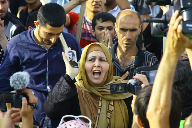 Nevreste Ibrahomova, head of Azerbaijan Islamic Party's Women Council, holds the photo of an arrested Azerbaijani Islamist and chants freedom to him. Photograph by Shahla Sultan 
