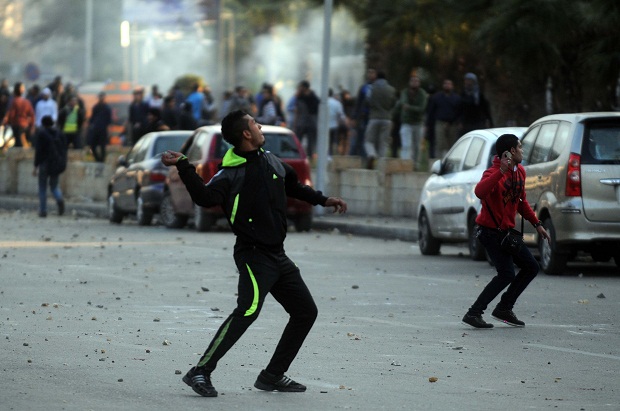 An alleged supporter of ousted President Mohamed Morsi clashes with Egyptian security forces in front of Cairo University, Egypt 12th January 2014 (Image: Nameer Galal/Demotix) 