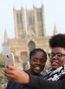 What A Liberty! project members Alisia Usher and Victoria Sajuyigbe take photos during a walk along Lincoln Castle's wall. Credit: Bill Thompson