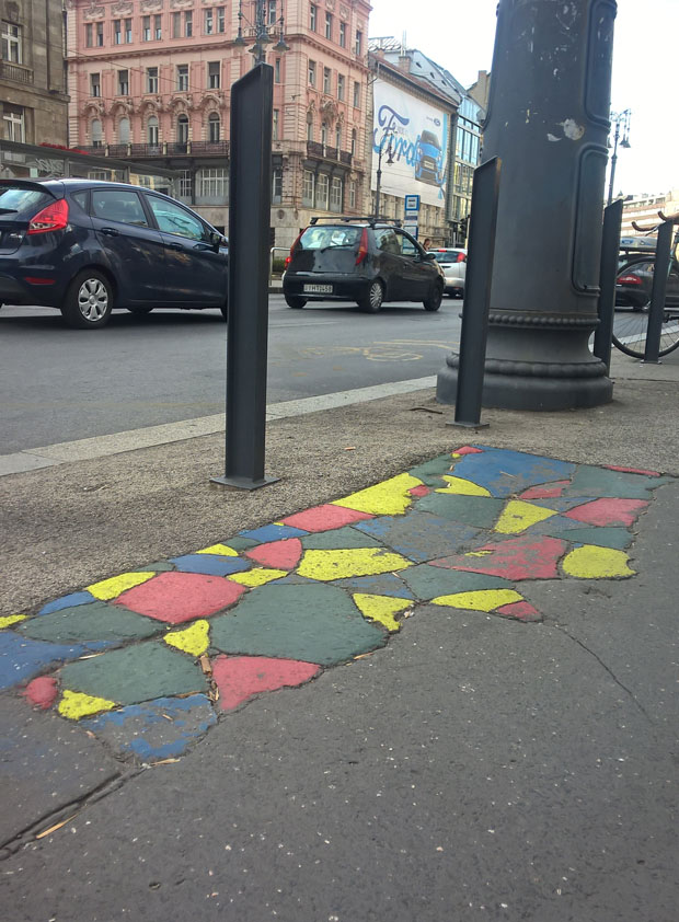 Anonymous volunteers have joined the satirial political party the Two-Tailed Dog party (MKKP) to paint cracked pavement on the streets of Budapest. Image: Fruzsina Katona