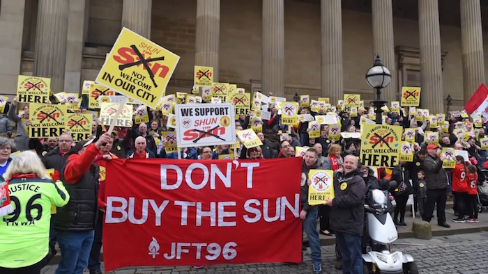 Protesters hold placards asking people not to buy the Sun