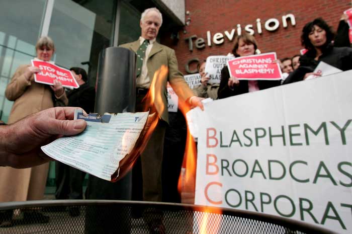 Members of Christian organisations burn TV licenses during a demonstration outside the BBC,