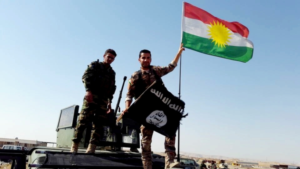 Iraqi Kurdistan military forces, the Peshmerga, replace an ISIS flag with the Kurdish flag near Mosul, Iraq, Kurdishstruggle/Flickr