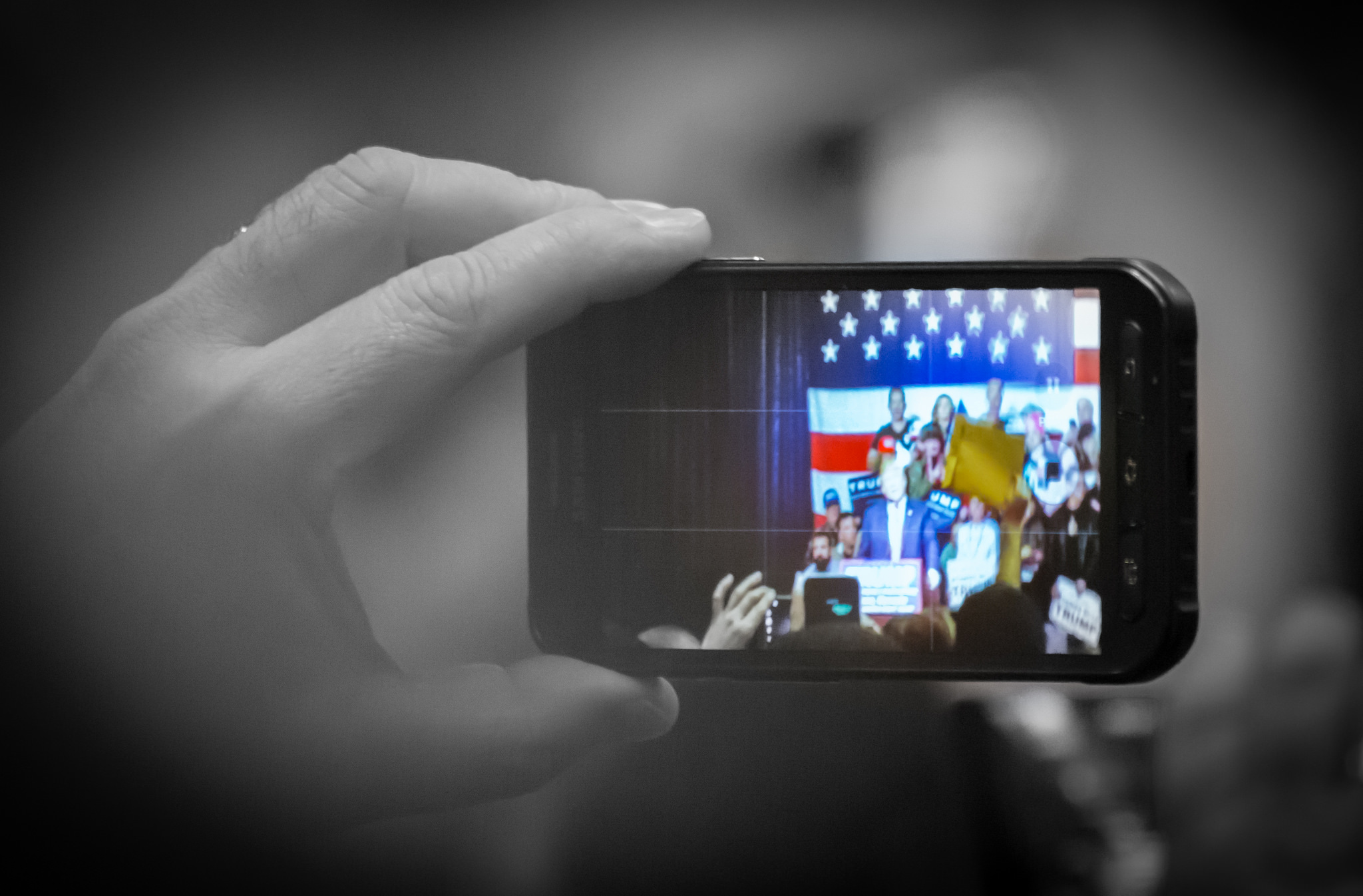 A member of the audience takes a photo of Donald Trump during a rally in Reno, Nevada during his campaign run, Darron Birgenheier/Flickr