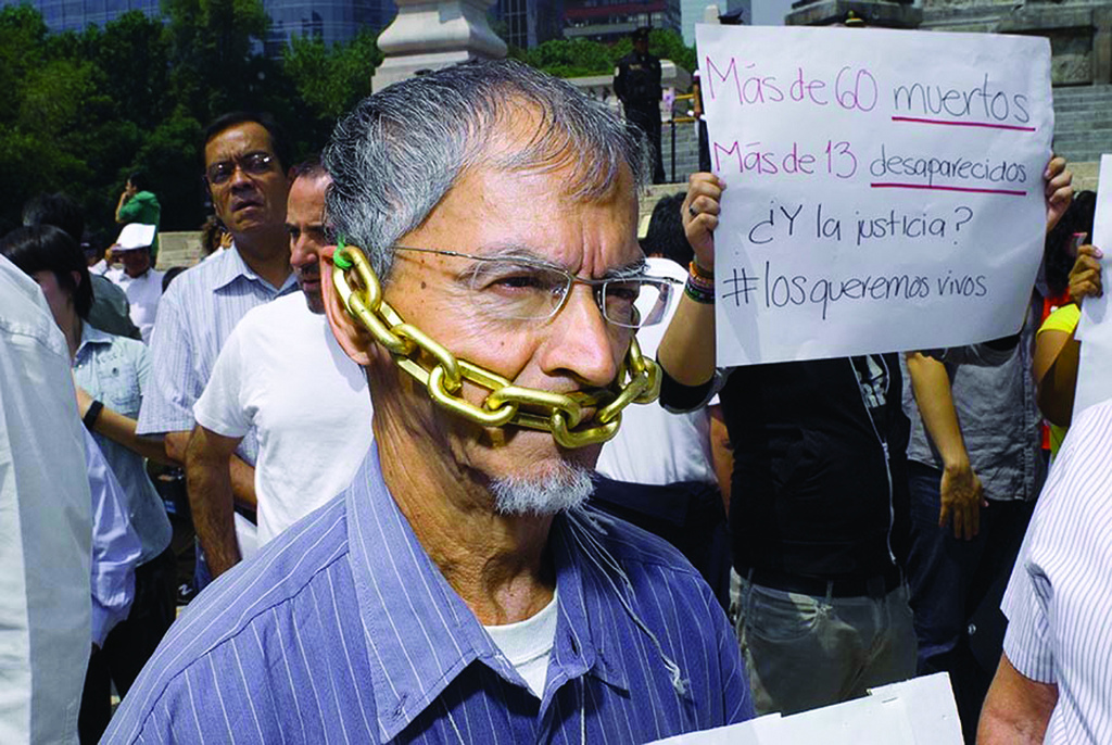 Un periodista mexicano sujeta una cadena alrededor de su boca durante una marcha silenciosa de 2010 en protesta contra los secuestros, asesinatos y violencia que sufren los periodistas del país, John S. and James L. Knight/Flickr