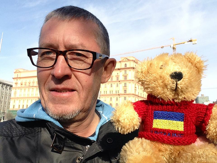 Russian journalist Alexander Shchetinin, pictured in front of the former headquarters of the KGB in Moscow with a stuffed bear.