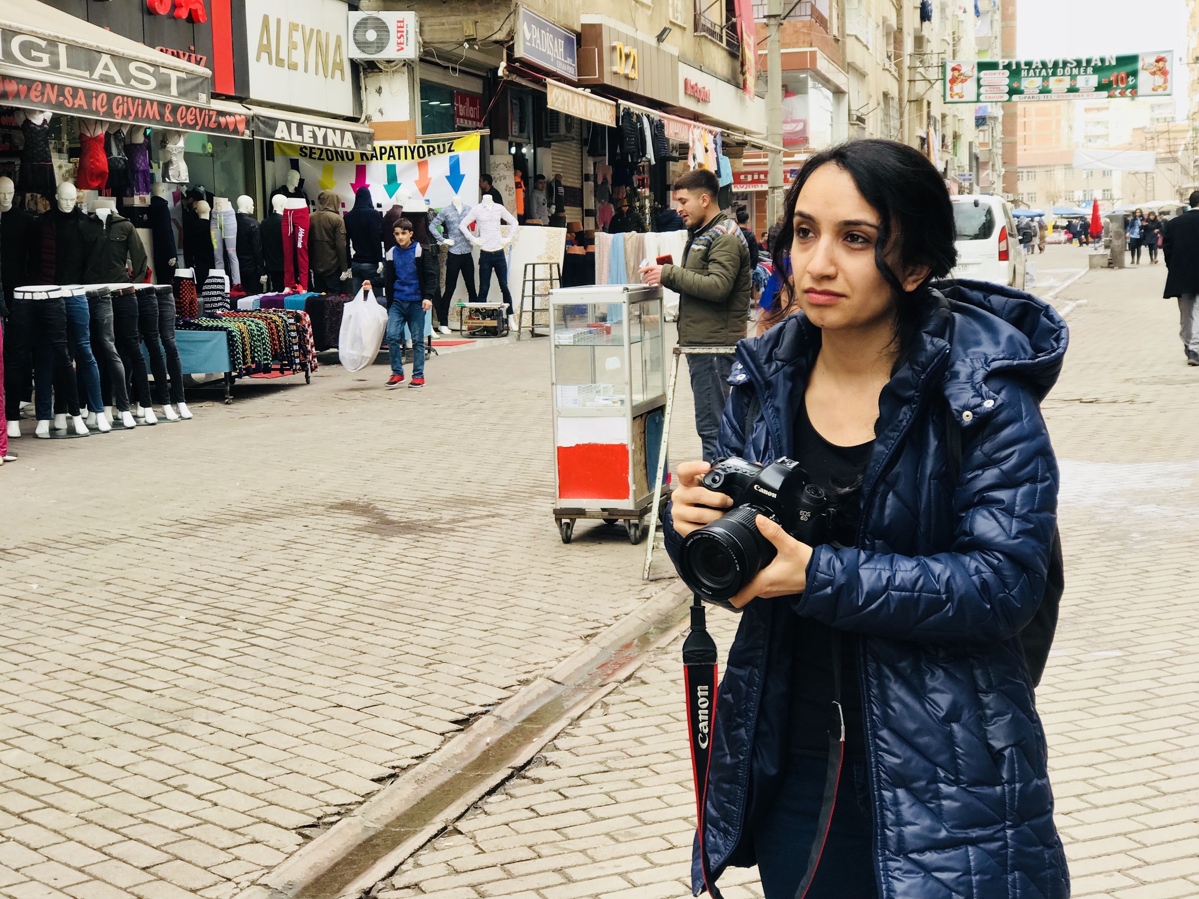 Jin News reporter Sehriban Aslan takes pictures at the market in Diyarbakir's Baglar district. (c) Ozgun Ozcer (2)