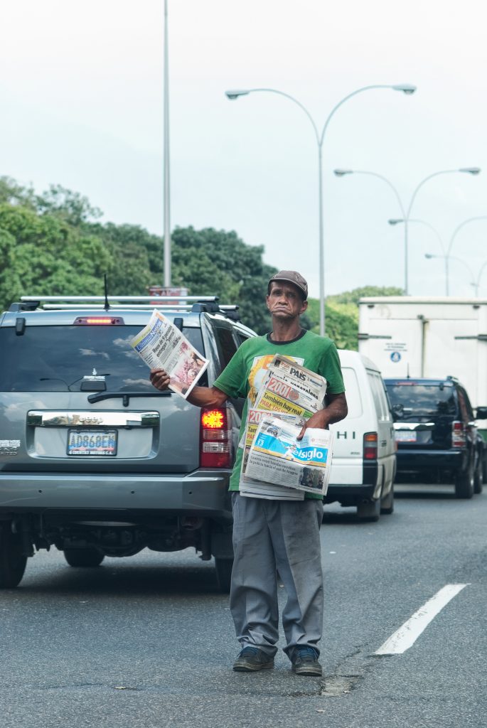 Un hombre vende periódicos en Caracas, Venezuela, FStoplight/iStock