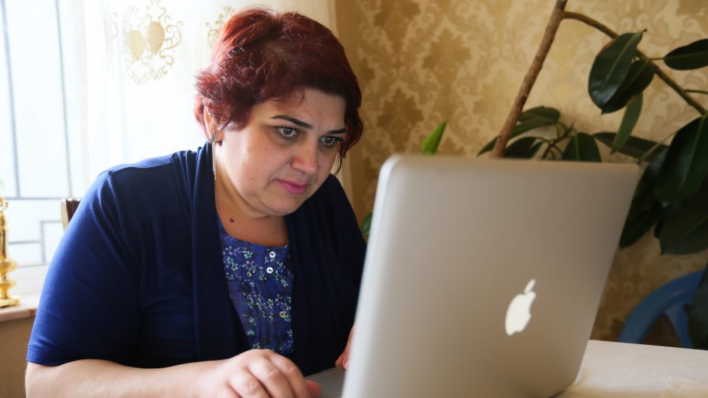 Journalist Khadija Ismayilova sits at a laptop computer. Credit: Aziz Karimov
